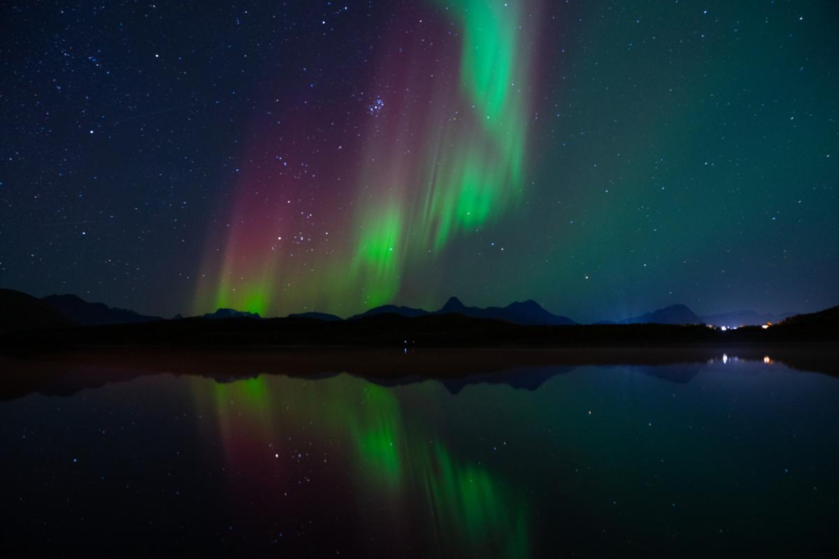 Nordlys jørn uit.jpg nordlys over mørke fjell og en fjord